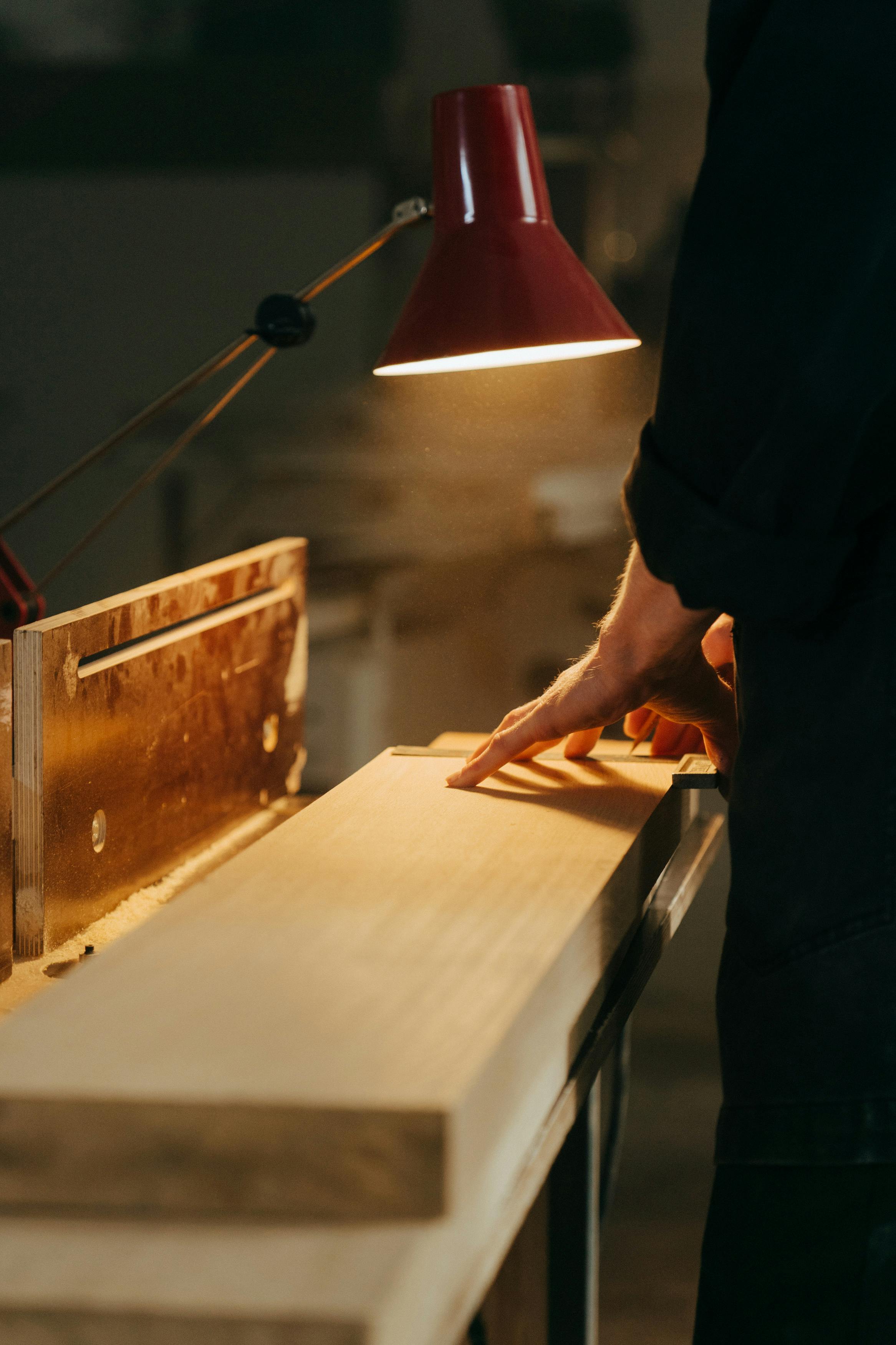 person touching brown plank